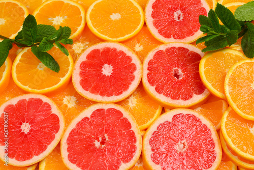 Fototapeta Naklejka Na Ścianę i Meble -  Slices of oranges and a grapefruits and mint as a background.