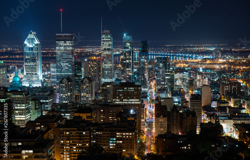 Night view of Montreal skyline with tall skyscrapers and busy street