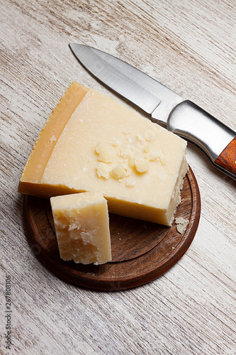 CHEESE AND POCKET KNIFE ON CLEAR WOOD BACKGROUND