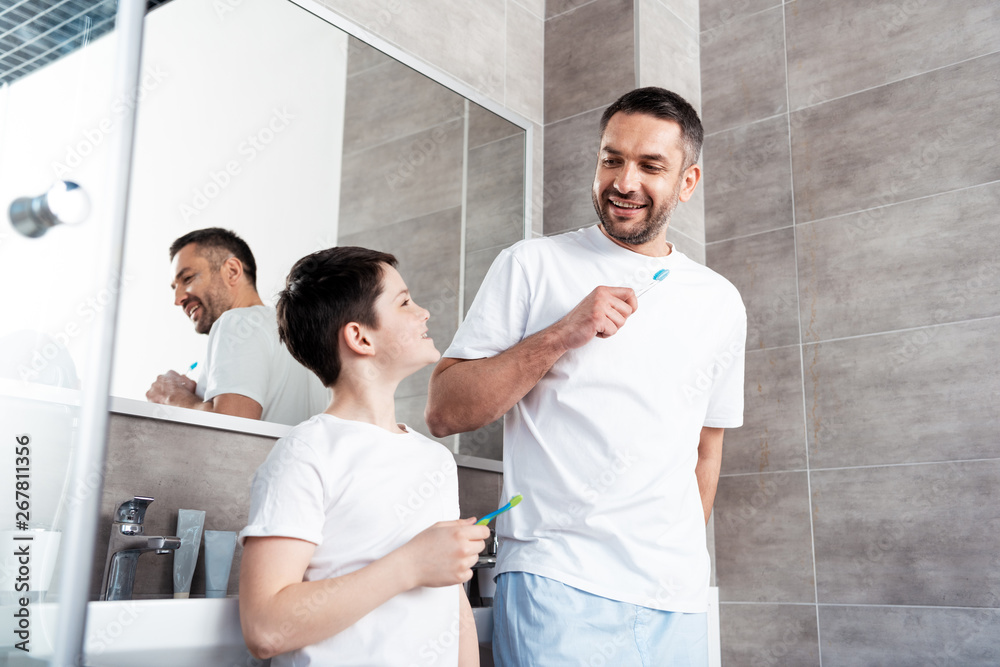 Fototapeta premium happy father and son brushing teeth in bathroom