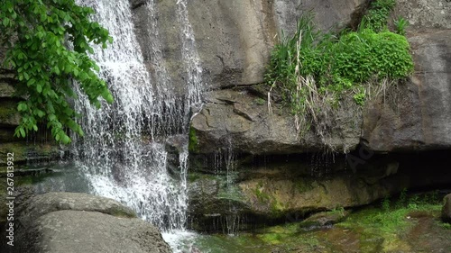 Waterfall in public park, fast streaming water.