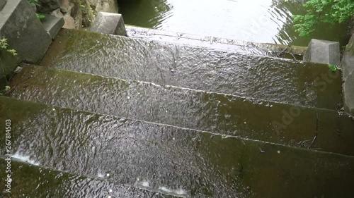Waterfall rapids in public park, fast streaming water.