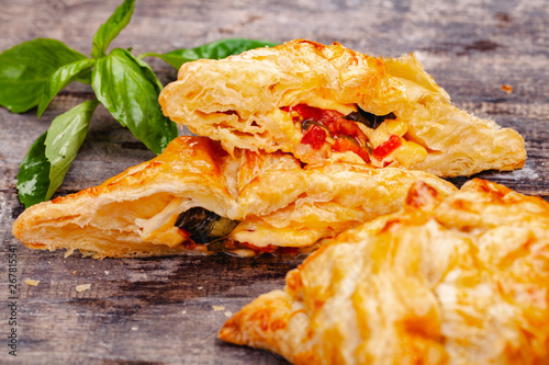 Puff pastry with cherry tomatoes  mozzarella cheese and basil on wooden rustic table. Close up