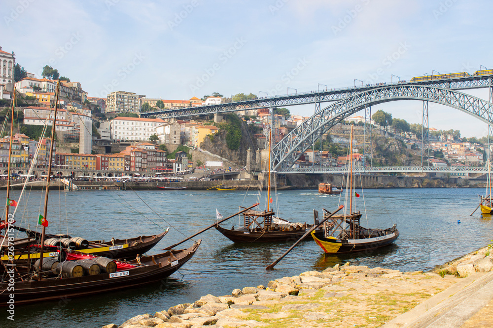 Port wine boats on Douro River with Dom Luis I Bridge and the old town background, at Ribeira, Porto, Portugal