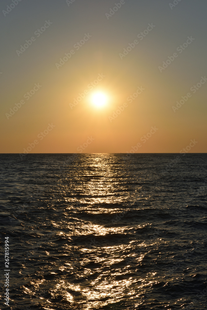 Beautiful orange sunset in the black sea with sun reflection in the city of Gelendzhik, Russia