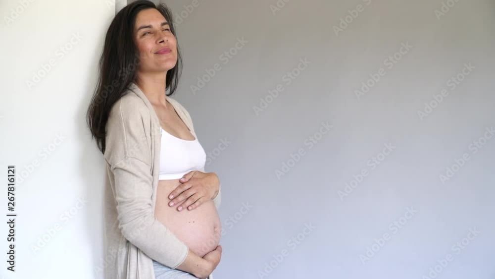 Pregnant woman looking at her belly, isolated Pregnant woman looking at her belly, isolated