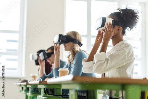 selective focus of multiethnic students using vr headsets in university photo