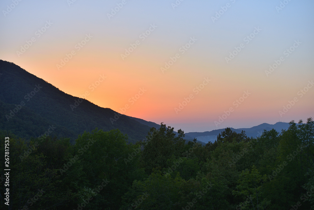 Evening landscape with mountains overgrown with trees against a sunset. Beautiful mountains around Geledzhik, Russia Evening landscape with mountains overgrown with trees against a sunset. Beautiful mountains around Geledzhik, Russia
