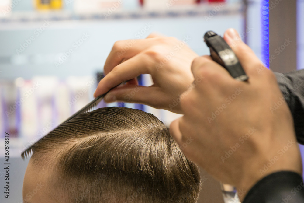 Fototapeta premium Hairdresser cutting hair. Hairdresser at work cutting customers hair