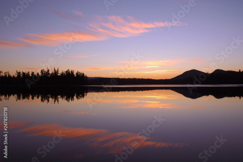 Sunset over Barnum Pond in the Adirondack Mountains with sky and mountains reflecting in calm water