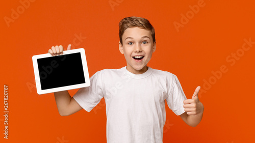 Teenage boy showing blank digital tablet screen