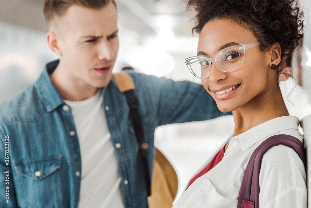 two multiethnic students standing in corridor in university two multiethnic students standing in corridor in university