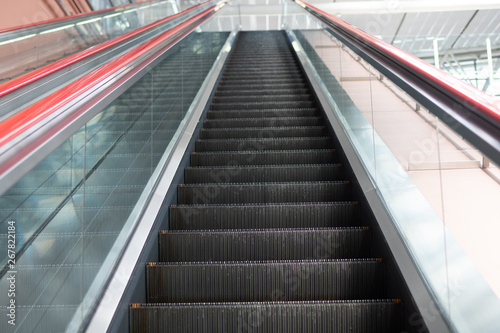 Escalator in shopping mall. Moving up and down staircase. electric escalator. © RobbinLee