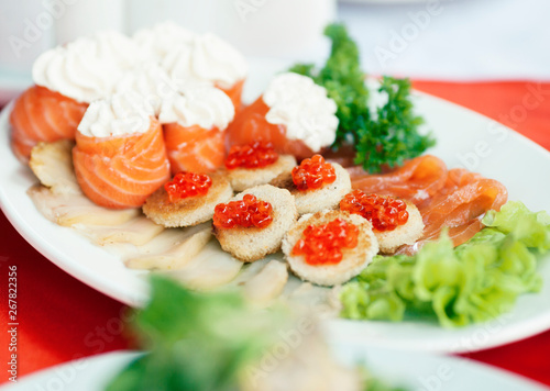 luxury served table with salmon and red caviar, salad on plate