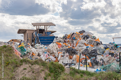 Obraz na płótnie Garbage dump with many colorful garbage, cloudy sky. w salonie