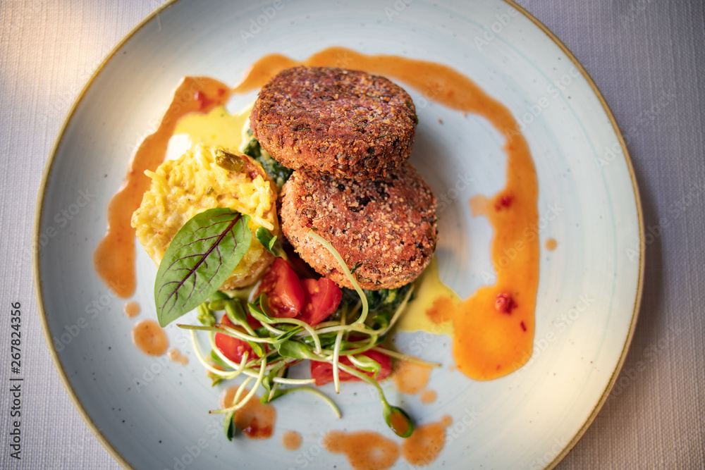 Delicious vegan burgers made from soya beams with yellow rice and salad.