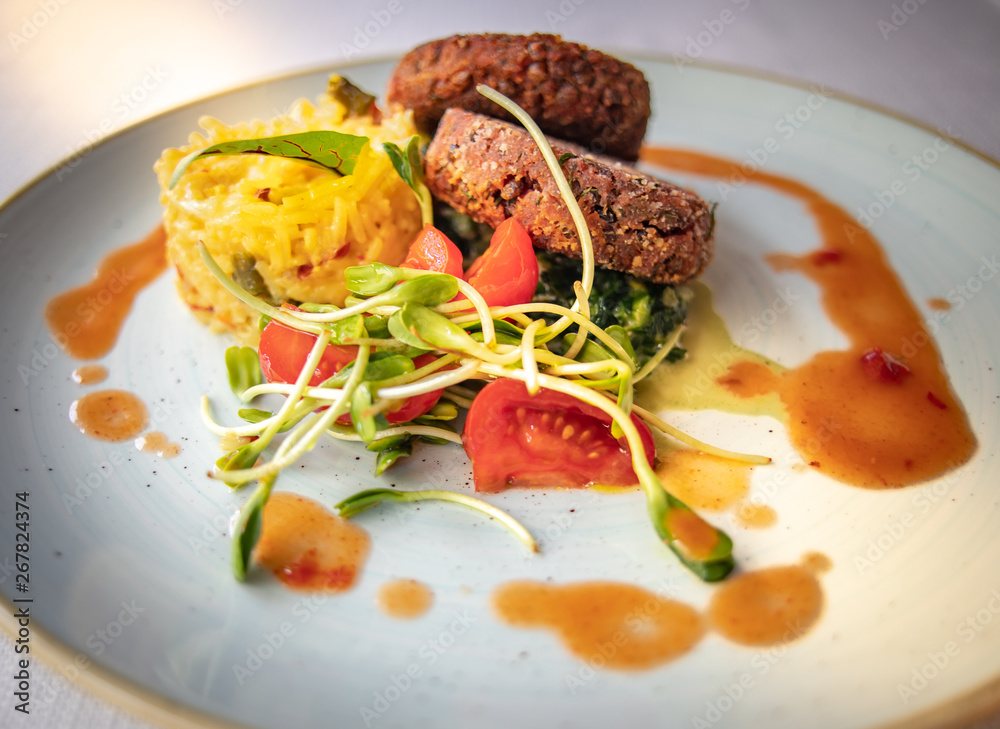 Delicious vegan burgers made from soya beams with yellow rice and salad.