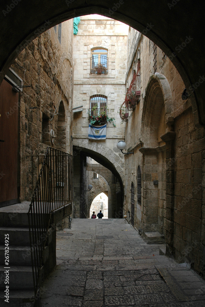 Arched street in old city of Jerusalem with two unidentifiable people walking Arched street in old city of Jerusalem with two unidentifiable people walking