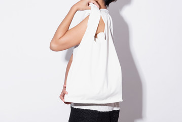 Girl is holding bag canvas fabric for mockup blank template isolated on gray background.  global warming concept.