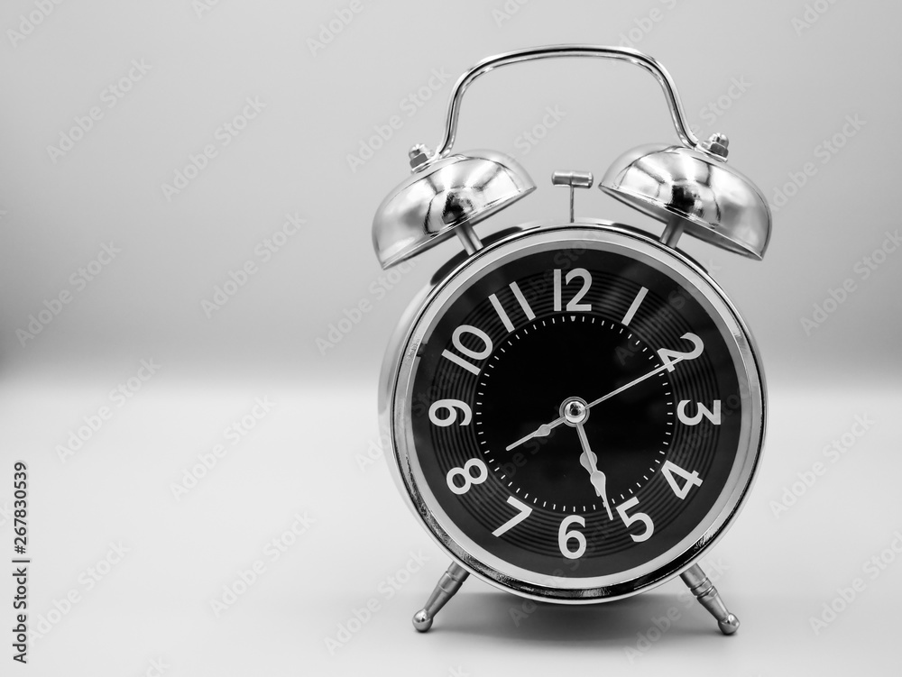 Black retro with silver border alarm clock that represent number of analog on isolated white background Black retro with silver border alarm clock that represent number of analog on isolated white background