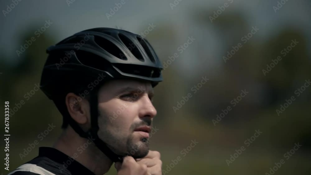 Cyclist Wearing Bicycle Helmet.Portrait Of Cyclist Wears Helmet.Cyclist Putting On Biking Helmet.Portrait Sportsman Wearing Cycling Gear.Cyclist Wearing Black Helmet.Athlete Putting On Bicycle Helmet. Cyclist Wearing Bicycle Helmet.Portrait Of Cyclist Wears Helmet.Cyclist Putting On Biking Helmet.Portrait Sportsman Wearing Cycling Gear.Cyclist Wearing Black Helmet.Athlete Putting On Bicycle Helmet.
