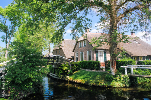 View of famous typical Dutch village Giethoorn with canals in the province of 'Overijssel. The beautiful Traditional Dutch House and gardening city is know as "Venice of the North". © olenap