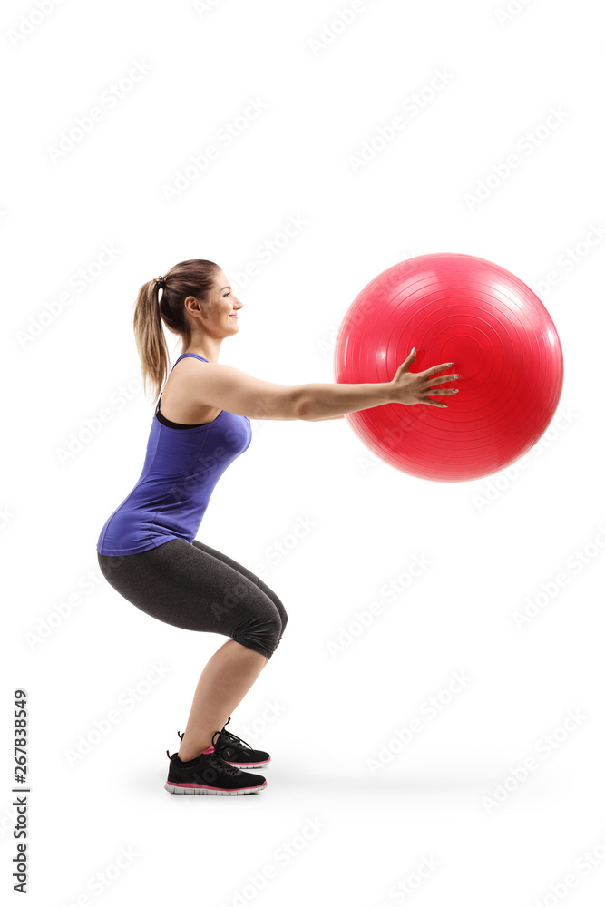 Young woman holding a fitness ball and exercising Young woman holding a fitness ball and exercising