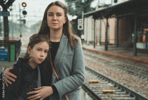 Photos Woman with her daughter on the railway station. Travel concept.
