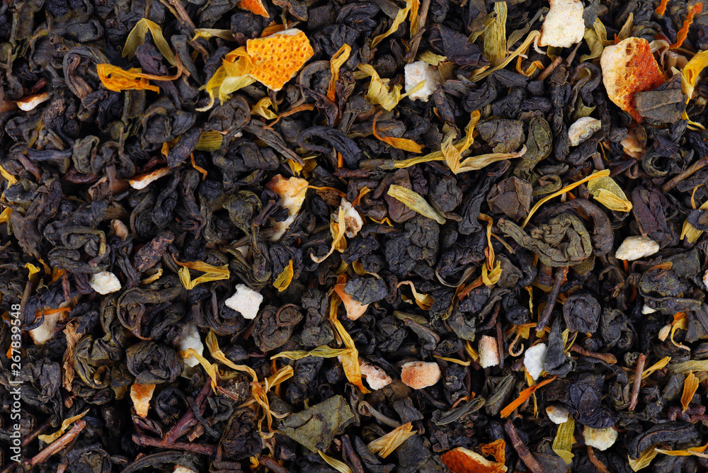 Green Ceylon tea with dry flowers and candied orange background. Green Ceylon tea with dry flowers and candied orange background.