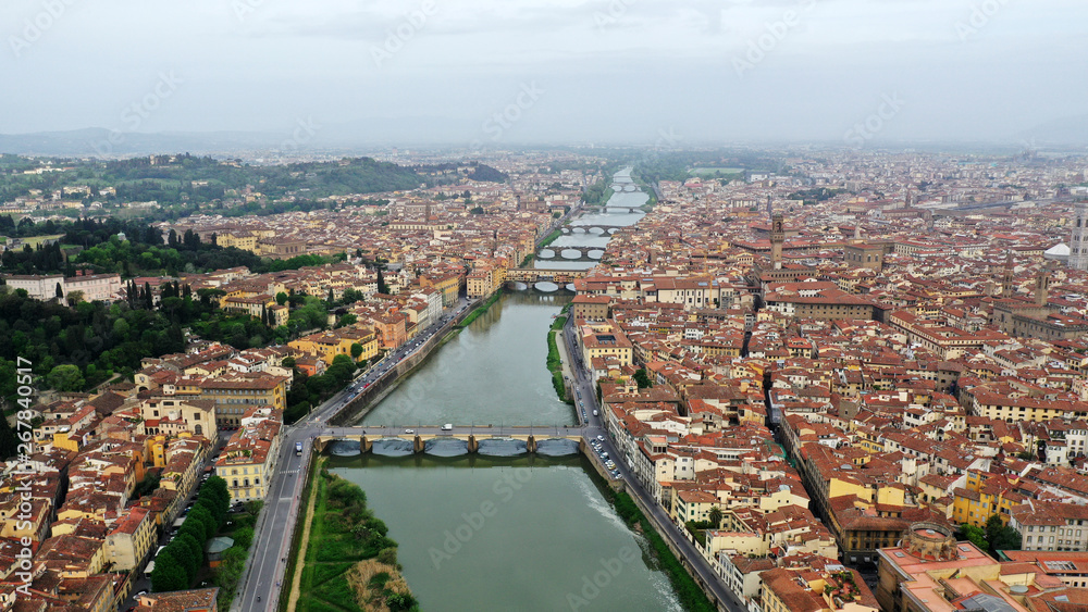 Aerial view of Ponte Vecchio bridge on Arno river in Florence city center, Italy. Italian orange roofs from drone near Cathedral. Tuscany.