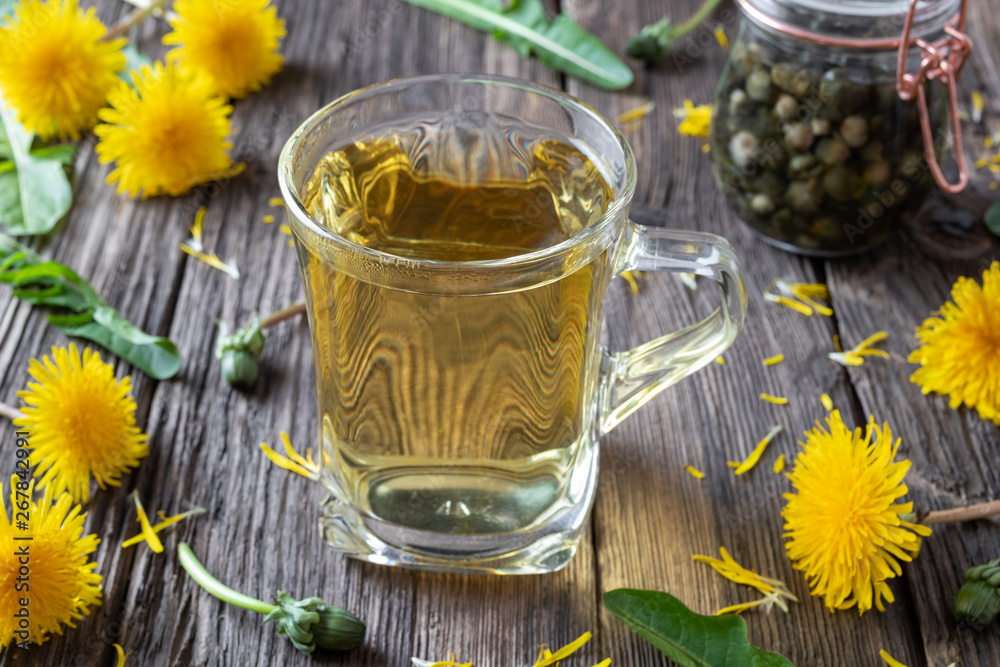 A cup of dandelion tea with fresh dandelion flowers A cup of dandelion tea with fresh dandelion flowers