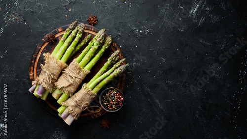 bunches of fresh green asparagus on a black background. Healthy food. Top view. Free space for your text.