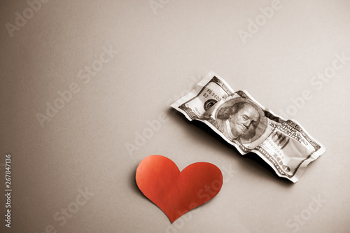 Fototapeta Naklejka Na Ścianę i Meble -  Red heart shape and 100 dollar bills on blue background.