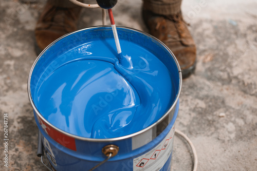 Картината върху платно Bucket of blue paint mixing on motion
