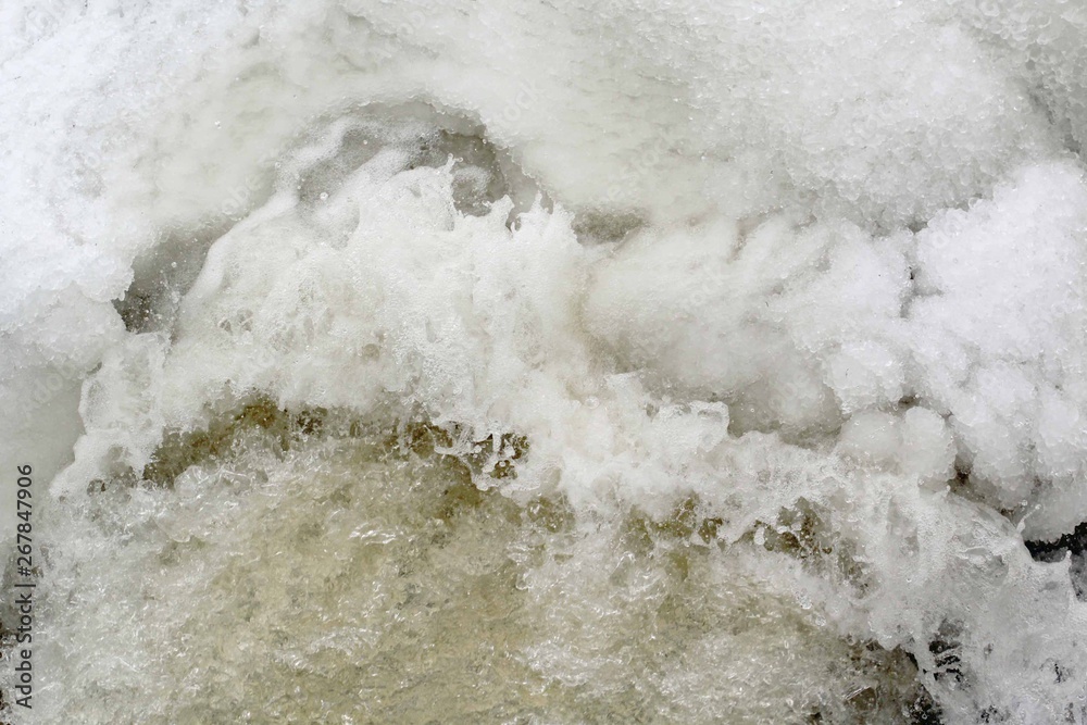 Ice cold water splashes from flowing river