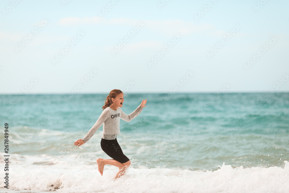 Young girl running through the waves at the beach Young girl running through the waves at the beach