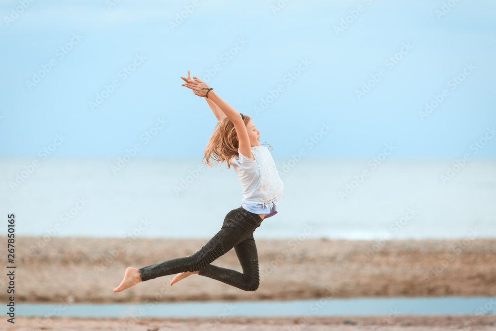 Young girl jumping in the air on the beach