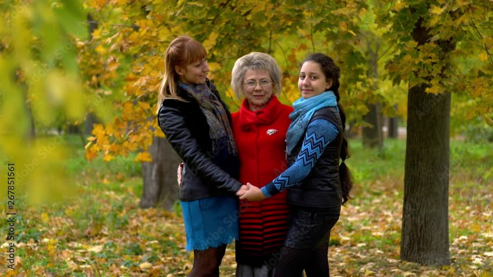grandmother, mother and granddaughter posing in the autumn forest grandmother, mother and granddaughter posing in the autumn forest