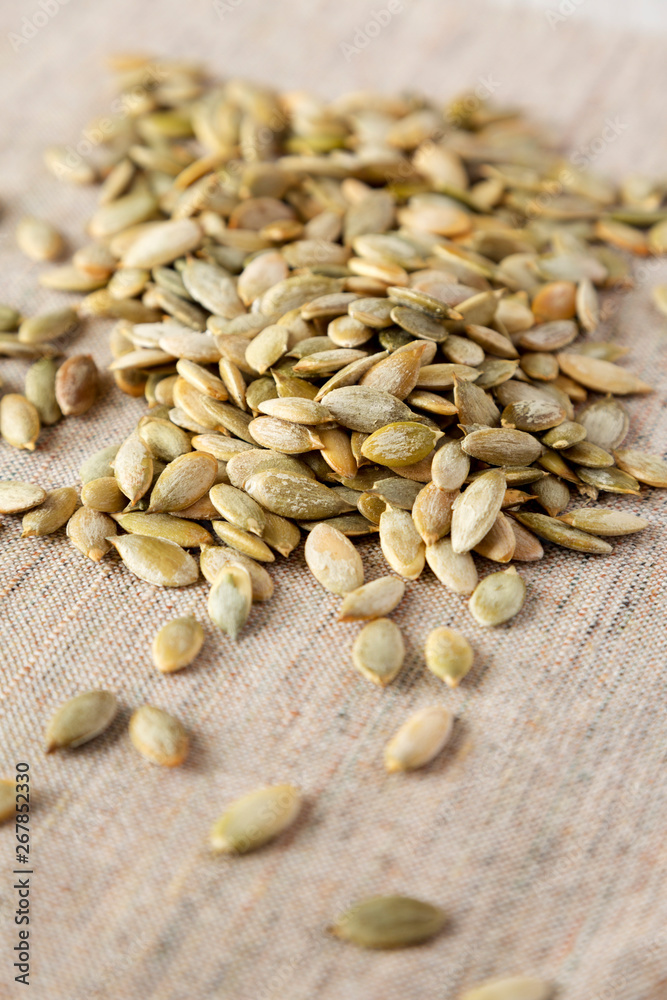Roasted pumpkin seeds on cloth, side view. Close-up. Roasted pumpkin seeds on cloth, side view. Close-up.