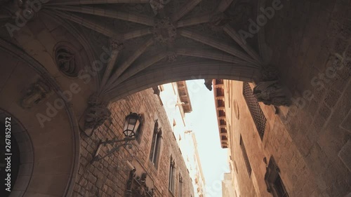 Bridge between buildings in Barri Gotic quarter of Barcelona, Spain. Old streets of Barrio Gotico in Barcelona, Catalonia. It is centre of old city of Barcelona. Center of touristic life. photo
