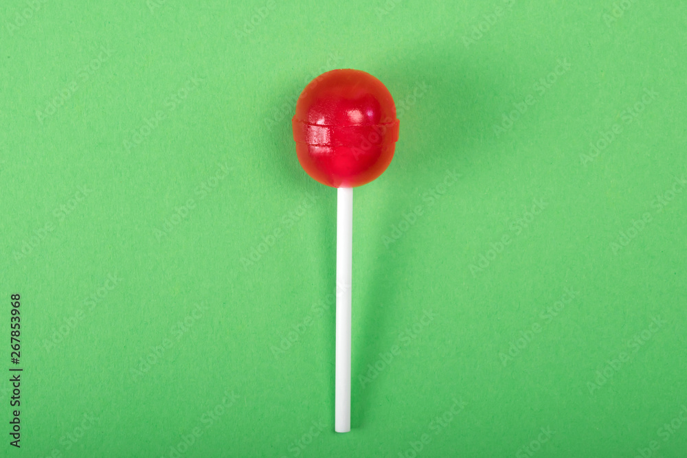 Red lolipop on green pastel background. sweet candy concept Red lolipop on green pastel background. sweet candy concept