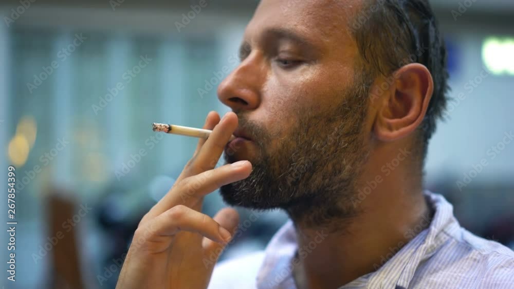 Young man smoking cigarette in the city
