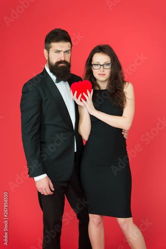 formal couple with red valentine heart. take my heart. one heart for two. sexy woman and mature man with beard. couple in love. formal couple. Love relationship. expert in love. formal fashion expert photo