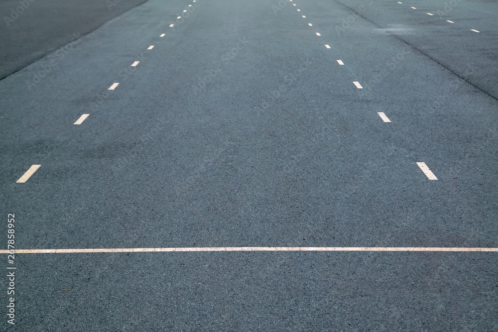 White dotted lines marking on asphalt natural background. Roadway line.