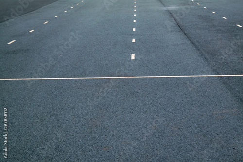 White dotted lines marking on asphalt natural background. Roadway line.