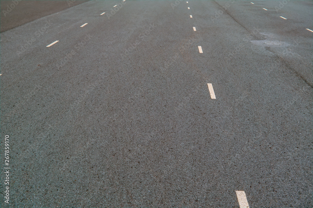 White dotted lines marking on asphalt natural background. Roadway line. White dotted lines marking on asphalt natural background. Roadway line.