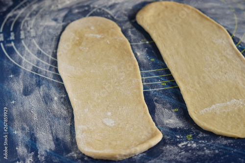 Roll out the dough for making buns in the shape of rabbits, step by step process, a culinary idea for children