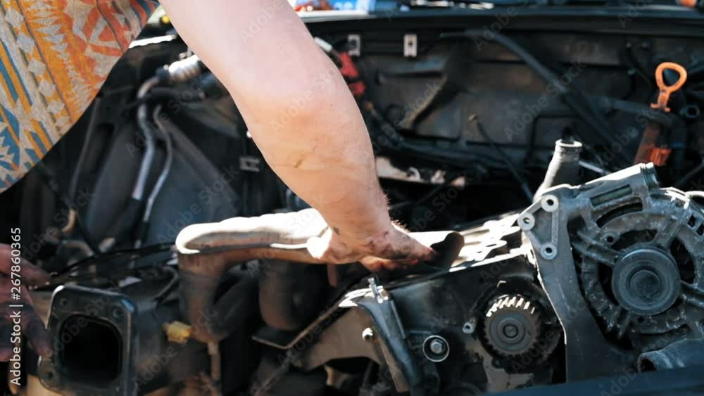 Close-up of auto mechanic hands with a wrench repairing car motor Close-up of auto mechanic hands with a wrench repairing car motor
