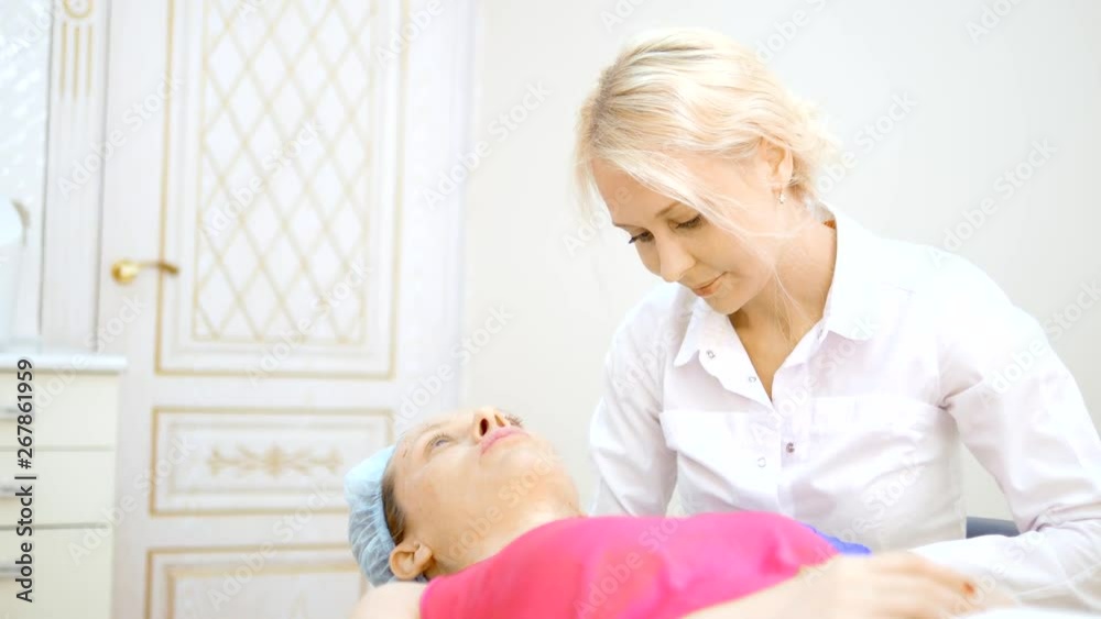 The cosmetologist makes injections, anti-aging procedures for tightening and smoothing wrinkles on the skin of the face and neck of a woman. The cosmetologist makes injections, anti-aging procedures for tightening and smoothing wrinkles on the skin of the face and neck of a woman.