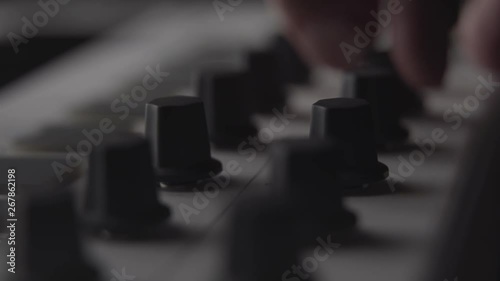DJ adjusting audio effect knobs on MIDI keyboard while making music